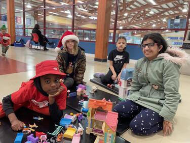 Four students playing with lego and sharing.